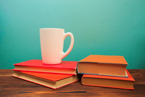 istock pile of old books with mug , panorma, good copy space  on blue background - Image 1165658617