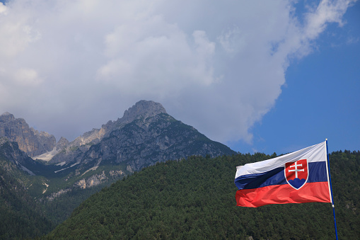 Slovakian flag fluttering in the wind. Mountain and Blue sky in the background