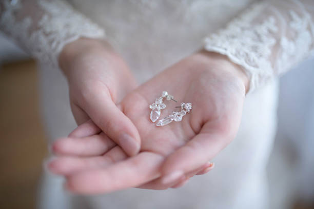 istock Bride getting ready for the wedding ceremony with focus on her hands holding delicately a pair of silver crystal drop earrings 1165661001