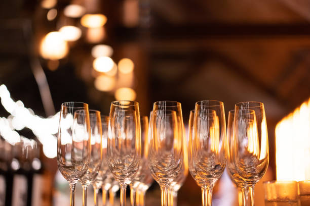 istock Champagne glasses in fine dining restaurant with yellow lights and blurred light bulbs 1165662170
