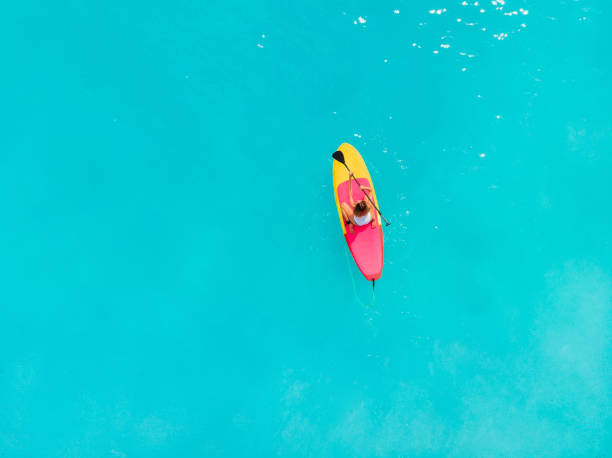istock Woman relax on stand up paddle board on a quiet blue ocean 1165663046