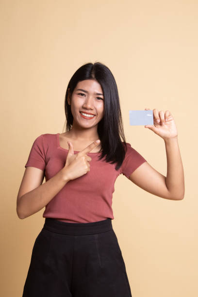 istock Young Asian woman point to a blank card. 1165664020