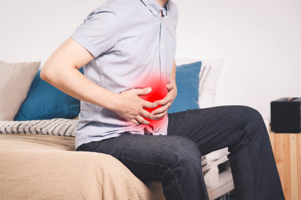 istock Stomach ache, man with abdominal pain suffering at home 1165665416