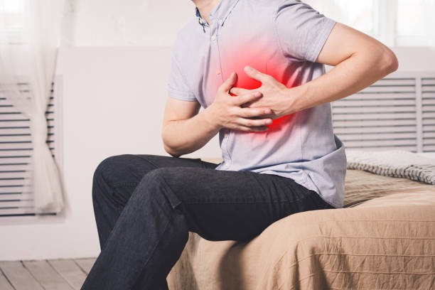 Heart attack, man with chest pain suffering at home stock photo