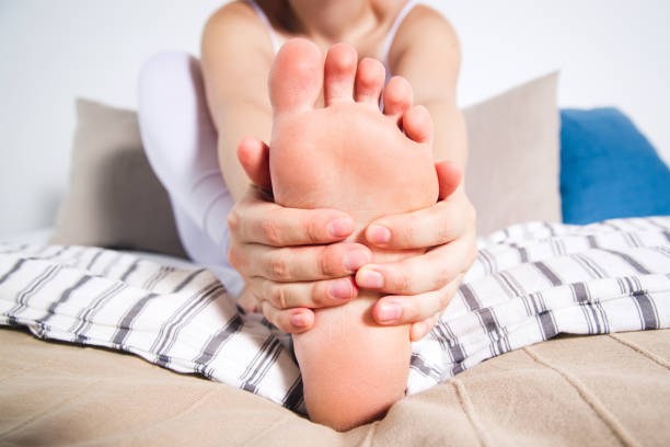 la gamba della donna fa male, dolore al piede, massaggio dei piedi femminili - podiatrist chiropractor massaging human foot foto e immagini stock