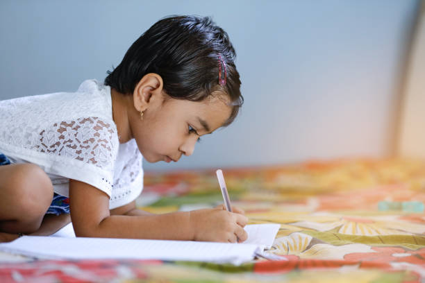 istock cute indian child studying at home 1165666836