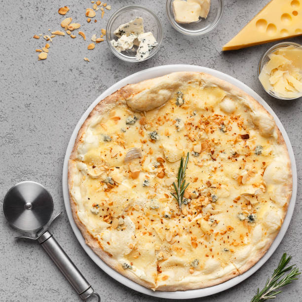 istock Four cheese pizza with cutter nearby, crop 1165670724
