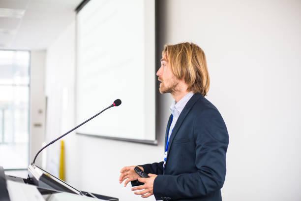 istock Handsome young man giving a speech at a conference 1165670864
