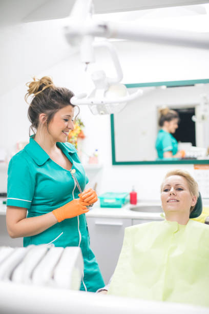 istock Woman dentist working at her patients teeth 1165673198