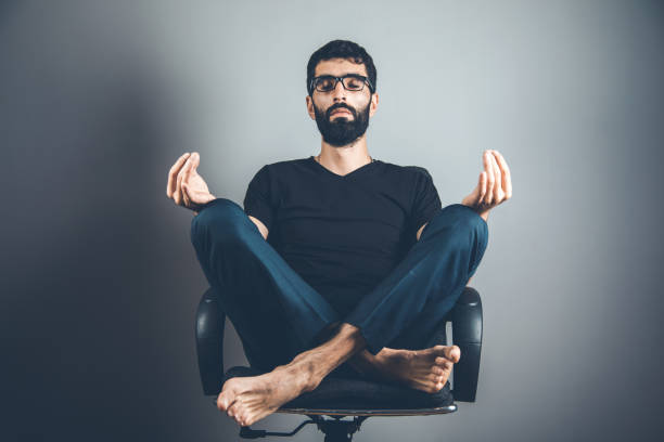 istock man meditation on chair on the dark background 1165673704