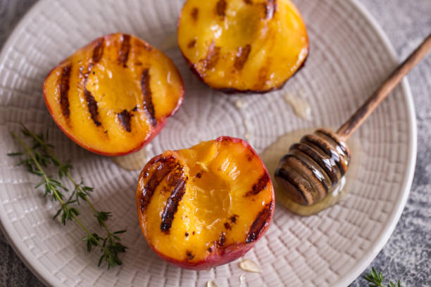 istock Summer dessert: Cooking Ripe grilled peaches with honey 1165674104
