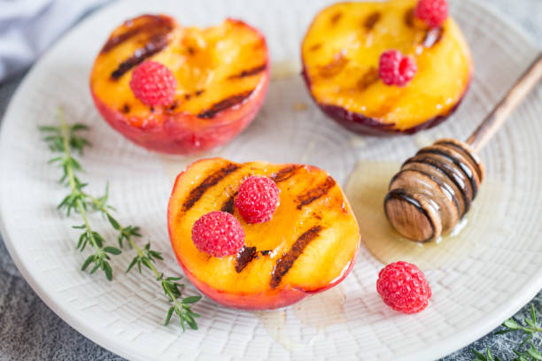 istock Summer dessert: Cooking Ripe grilled peaches with honey 1165674155