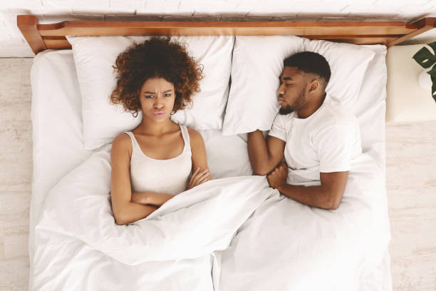 pareja joven en la cama que tiene problemas y crisis - couple love snoring sleeping fotografías e imágenes de stock