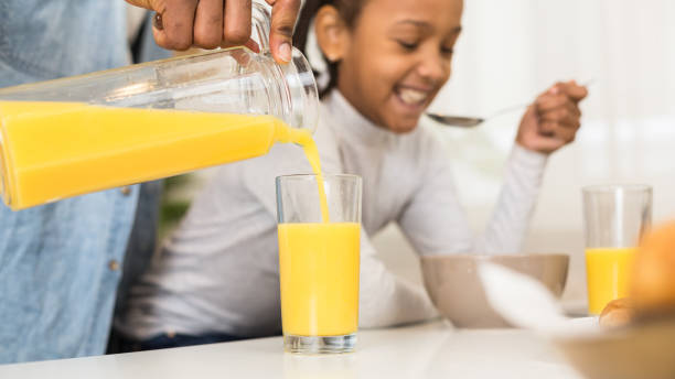 istock Father and daughter having orange juice for breakfast 1165676652
