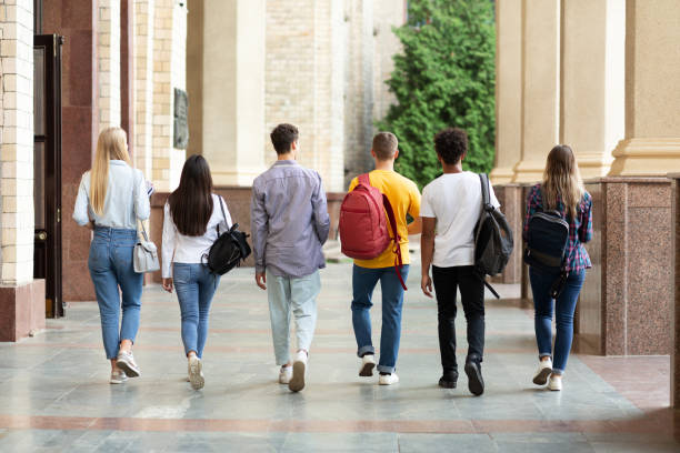 gruppo di studenti che camminano nel campus universitario dopo le lezioni - campus autumn walking university foto e immagini stock