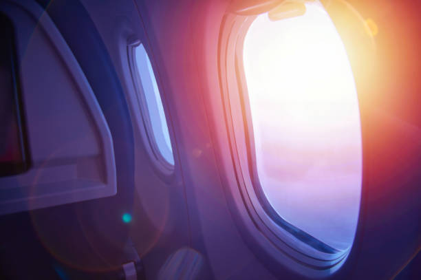concetto di viaggio. tramonto attraverso la finestra di un aereo. interno dell'aereo. - wing airplane window sunset foto e immagini stock
