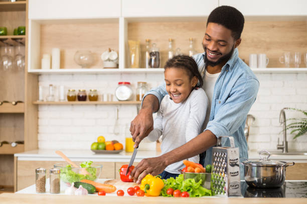 istock Dad teaching his daughter to cook salad 1165679535