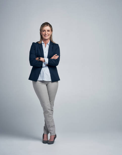 Self-confidence is the first requisite to great undertakings Studio portrait of a mature businesswoman standing against a grey background whole stock pictures, royalty-free photos & images