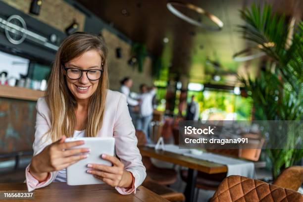 Pretty Young Female Manager Using Modern Digital Tablet At Cafe Stock Photo - Download Image Now