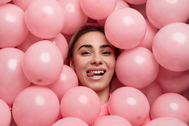 istock Stylish female under pink balloons 1165682458