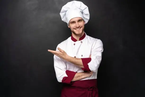 Photo of Chef presents something on a black background.