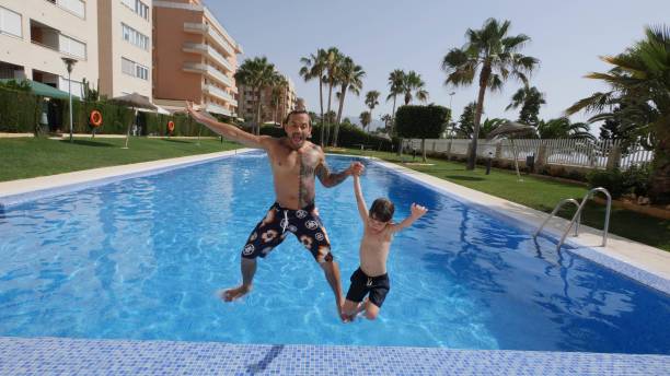 istock 5 years old and father playing at the pool in Summer 1165683306