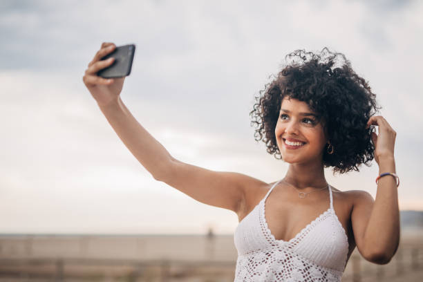istock Beautiful woman taking a selfie on the beach 1165684916
