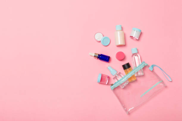 istock Group of small bottles for travelling on pink background. Copy space for your ideas. Flat lay composition of cosmetic products. Top view of cream containers with cotton pads 1165687202