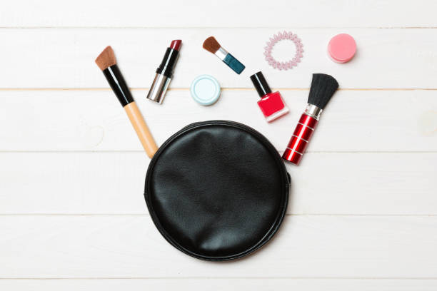 top view od cosmetics bag with spilled out make up products on wooden background. beauty concept with empty space for your design - pampering nail polish make up spilling imagens e fotografias de stock