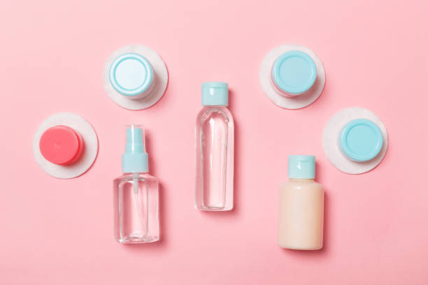 istock Group of small bottles for travelling on pink background. Copy space for your ideas. Flat lay composition of cosmetic products. Top view of cream containers with cotton pads 1165687426