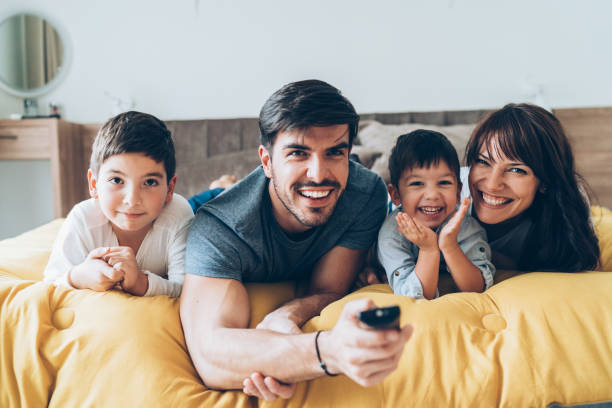 家族とのテレビ時間 - bed cheerful enjoyment excitement ストックフォトと画像