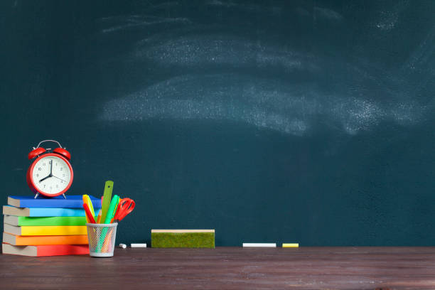 istock Alarm clock on books on school teacher's desk 1165689439
