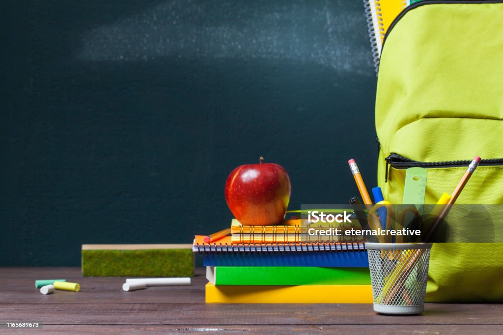 Stack of books, stationery and education supplies on wooden desk Stack of books, stationery and education supplies on wooden desk. Back to school concept. Backpack Stock Photo