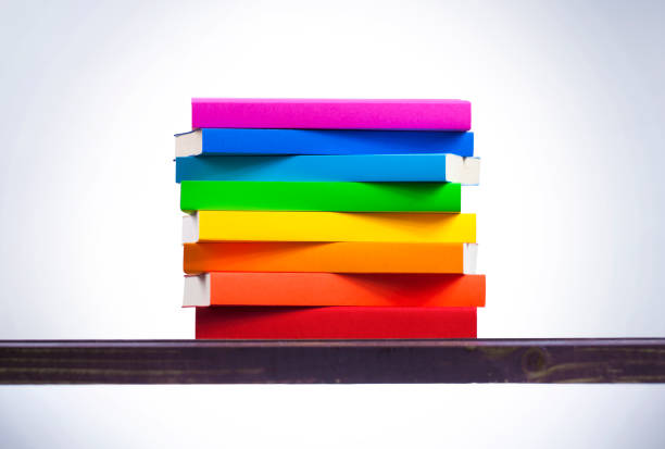 istock Stack of colored books on wooden table 1165690068