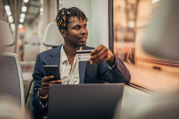 istock Black businessman with credit card in subway train 1165692235