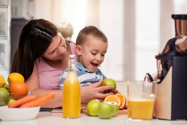 istock Mother and her son making fresh orange juice 1165693844