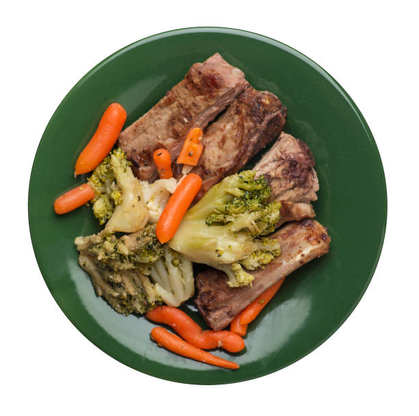 istock grilled pork ribs with broccoli cabbage, carrots and garlic on a plate. fried   ribs with vegetables on a white background. hearty rustic food top view 1165696351