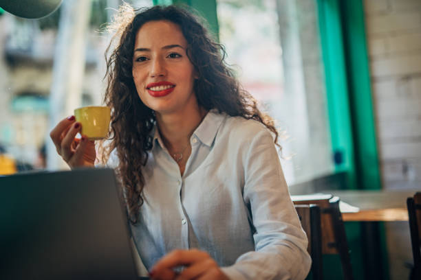 istock Beautiful lady using laptop in cafe 1165696533