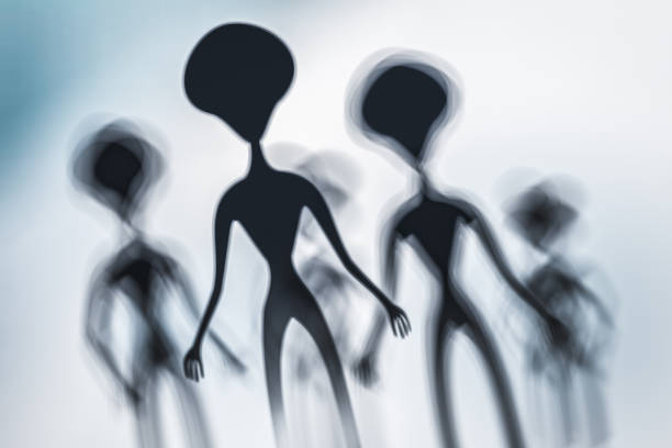 Silhouettes of spooky aliens and bright light on behind them - UFO concept