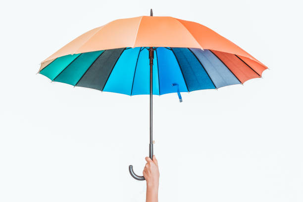 istock Rainbow umbrella in female hand isolated on white 1165698381