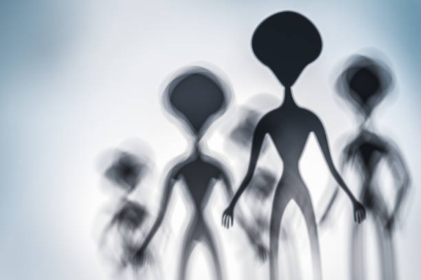 Silhouettes of spooky aliens and bright light on behind them Silhouettes of spooky aliens and bright light on behind them - UFO concept grey alien stock pictures, royalty-free photos & images