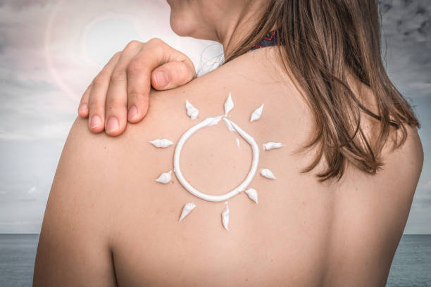 istock Woman with suntan lotion on her shoulder in sun shape 1165699083