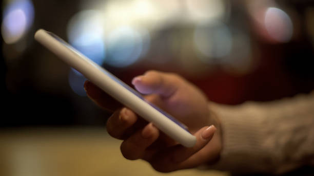 giovane donna che scorre smartphone, seduta al bar e rilassante, coffeebreak - business blurred motion text messaging defocused foto e immagini stock