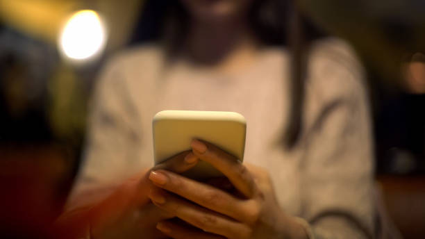istock Young lady typing on smartphone checking mail, online hotel booking, application 1165700830