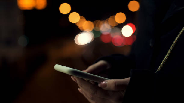 istock Lady calling taxi using phone application standing near highway, illumination 1165700998