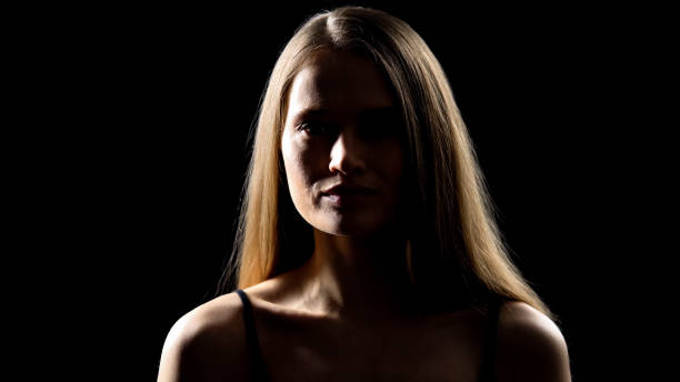 istock Pretty female looking at camera and smiling, isolated on black background 1165701336