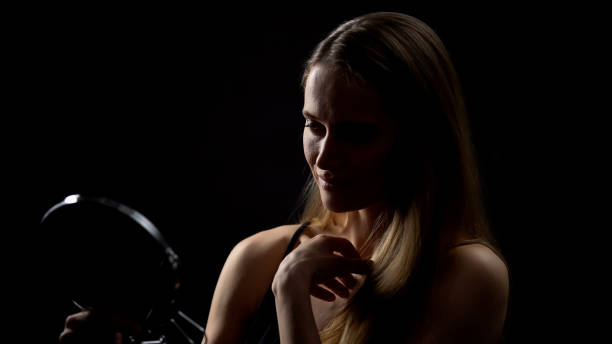 istock Young woman looking at mirror reflection, enjoying beauty, high self-esteem 1165701650