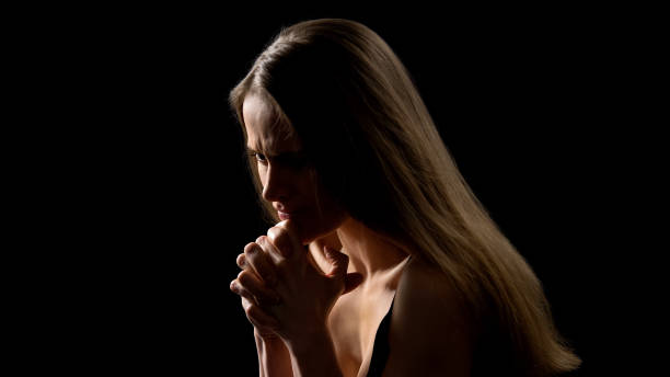 istock Worried woman suffering from depression and life problems, black background 1165701657