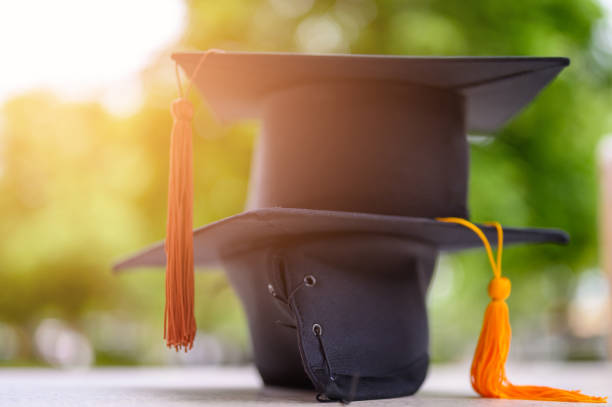 istock Black Graduation Hat placed on a wooden floor 1165702643