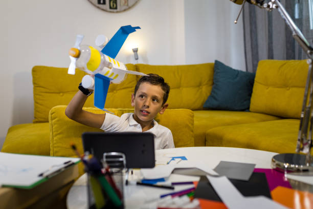 istock Boy playing with an airplane made from recycled paper and plastic 1165703322